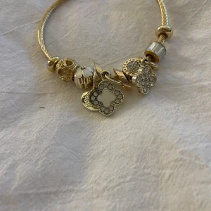 Armband - Säljer mitt guld isadora inspirerat armband med vita och guld berlocker. Är aldrig använt och är så i nytt skick 💗