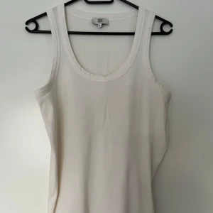 Noa Noa vit tanktopp, storlek XL - Vit ribbad tanktopp med rund halsringning från Noa Noa. Enkel och stilren design. Storlek XL. Nyskick. 100% bomull.   Mått:  Längd ca 59 cm Byst ca 45 cm Midja ca 48 cm