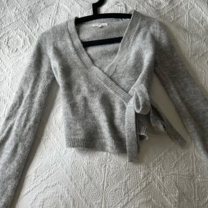 Stickad tröja - Jag säljer denna stickade omlott tröjan för att den inte har kommit till användning. Den är använd fåtal gånger och är i nyskick. Nypris är 399.