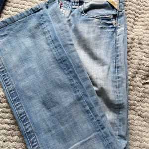 Ljusblå jeans från Replay - Säljer ett par ljusblå jeans med snygga detaljer på bakfickorna. Jeansen har normal passform och är Lågmidjade. Och bootcut. 
