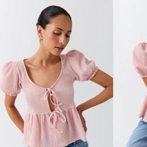 Ljusrosa blus med puffärmar och knyt - Supersöt ljusrosa blus med puffärmar och två knyt framtill. Perfekt till sommaren, använd fåtal gånger och är i väldigt bra skick ❣️skriv för fler bilder 