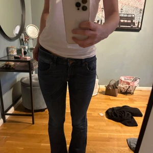 Blå jeans med normal passform - Snygga blå jeans med normal passform och klassisk femficksdesign. De har en knapp och dragkedja framtill. Perfekta för en avslappnad stil.