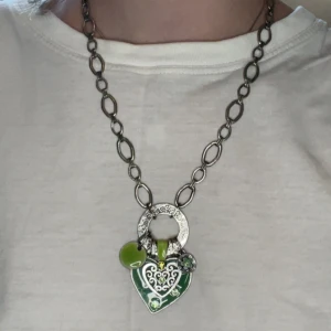 Smycke - grönt hjärta  - Säljer ett somrigt halsband i grön färg prydd i  glittriga stenar och bara gulliga detaljer såsom blommor. Smycket är från början ifrån Tstreet