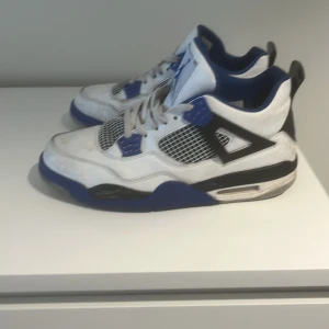 Nike Air Jordans i blått och vitt - Säljer ett par Nike Air Jordans i en snygg kombination av blått, vitt och svart. Skorna har snörning och en rund tå. Perfekta för dig som vill ha en stilren och sportig look.