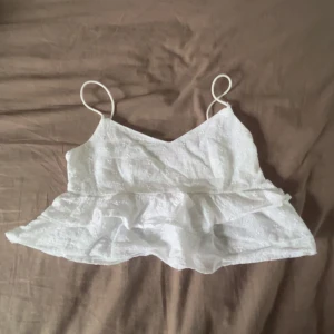 Vit spetslinne  - Säljer en vit spetslinne från SHEIN med tunna axelband och volangdetaljer.