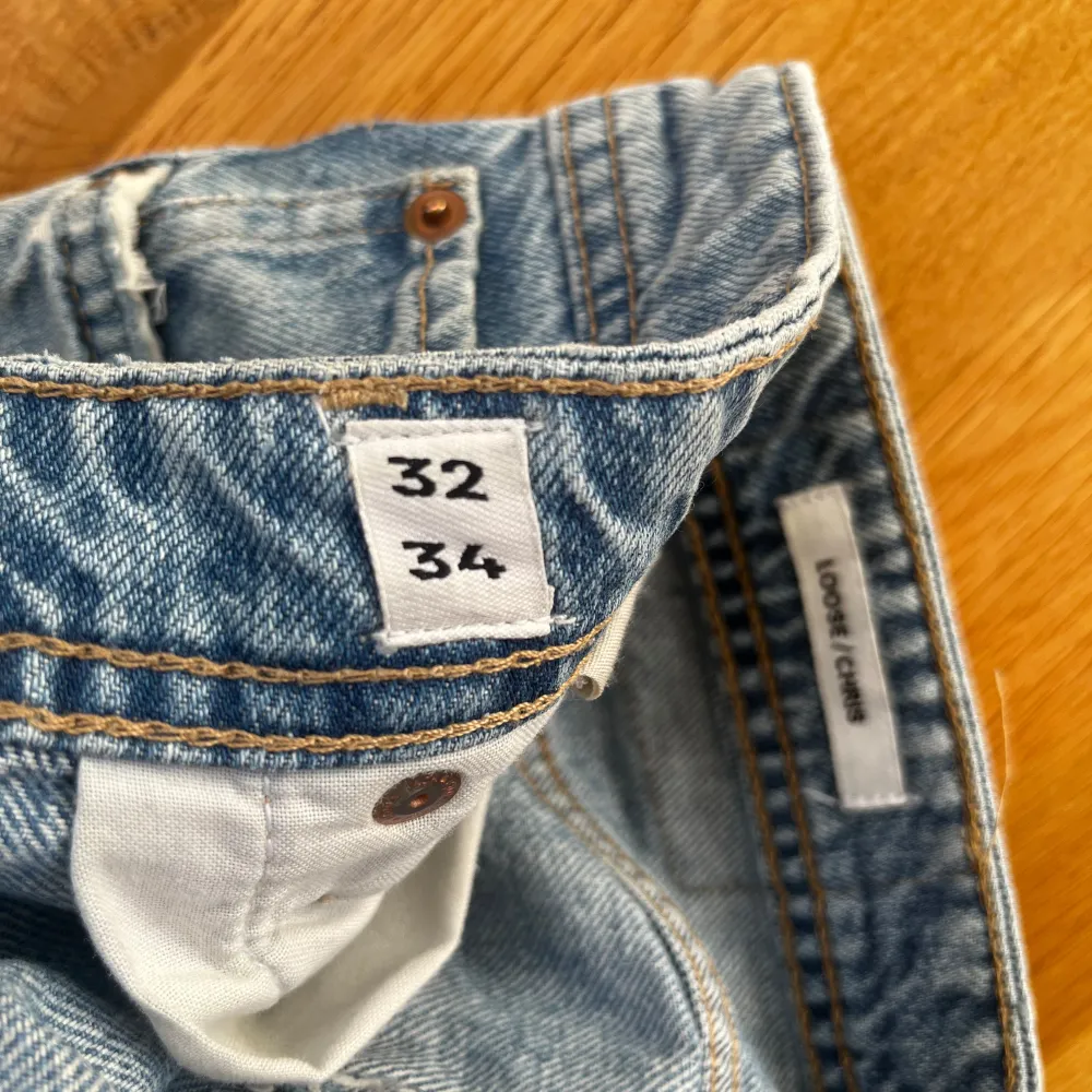 Säljer ett par klassiska blå jeans från Jack & Jones. De har en tapered/regular fit och är tillverkade i denim med en snygg fransad kant vid benslutet. Perfekta för en avslappnad stil. Lite slitna längst ned på benen. . Farkut & Housut.