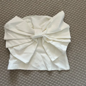 Vit axelbandslös topp med stor rosett - aldrig använd jätte finnn💕