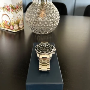 Silverfärgad klocka från LIGE - Snygg silverfärgad klocka från LIGE med svart urtavla och kronografdetaljer. Klockan har en robust metallarmband och tydliga markeringar på urtavlan. Perfekt för den som gillar en stilren och modern look.