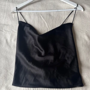 Svart satinlinne - Svart linne i satin med tunna axelband och korsad rygg. 