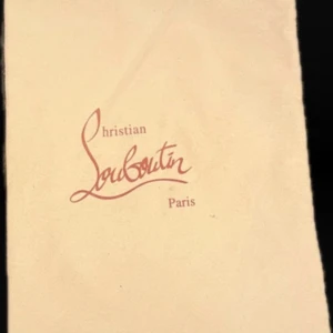 Christian Louboutin Dust Bag - Beige dust bag från Christian Louboutin med logotyp i röd text. Perfekt för att skydda dina exklusiva skor. (2st)