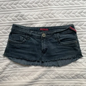 Minikjol  - Snygg mini jeanskjol från ML Jeans med fransig kant och broderade detaljer på bakfickorna. Kjolen har en klassisk femficksdesign och knappstängning fram. Perfekt för en cool och avslappnad stil 💞Jag har själv klippt av ett par jeans och frasat kanterna så dessa finns inte att köpa på annat håll!! 