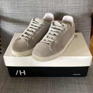 Grå sneakers från Selected Homme - Snygga grå sneakers från Selected Homme i mocka med vit sula. Skorna har klassisk snörning och en stilren design som passar perfekt till vardags. Perfekta för en avslappnad och trendig look. Köpta för 1200kr men säljer dom för 600 efter som dom nästan inte är använda. Pris kan diskuteras 