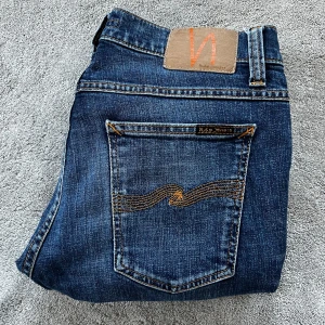 Blå jeans från nudie - Skick: 10/10 - Storlek: W32 L34 - Längd:104,5cm Midja:42cm ben:15,5cm - Nypris: 2000 kr+