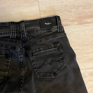 Fina Pepe Jeans  - Snygga svarta jeans med detaljer på bakfickorna från Pepe Jeans i strl 27/30, säljes då de inte kommer till användning, de är uppsprättade nere vid fötterna men går enkelt att sy upp till normal längd igen 💕 Hör av er vid frågor 