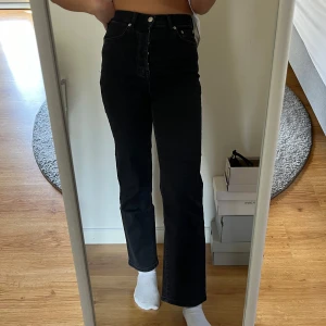 Svarta jeans med hög midja - Snygga svarta jeans med hög midja och med en rak stil. De har en klassisk femficksdesign och knappar framtill. Byxorna är lite för små för mig som är 170, så knapparna syns inte om man har rött storlek
