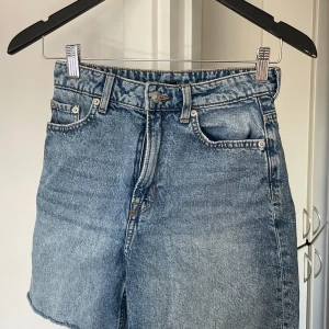 Blå jeansshorts - Snygga blå jeansshorts med klassisk femficksdesign och knappgylf. Perfekta för en avslappnad stil. De har en rå kant nertill som ger en cool och trendig look. från HM
