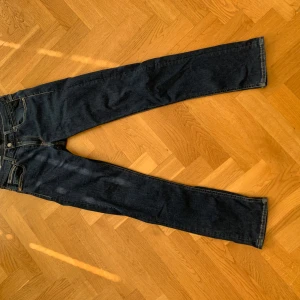 Mörkblå jeans från Replay - Snygga mörkblå jeans från Replay med klassisk femficksdesign och broderade bakfickor. Jeansen har en normal passform och är tillverkade i slitstarkt denim. Perfekta för en stilren look.