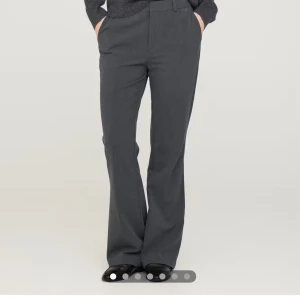 Gråa kostymbyxor med bootcut - Snygga svarta byxor med bootcut-stil. Perfekta för en stilren look. Byxorna har en hög midja och är tillverkade i ett bekvämt material som ger en smickrande passform.