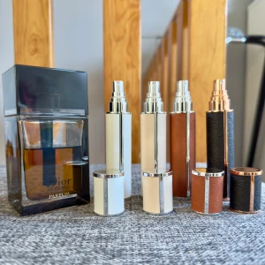 Dior Homme Parfum -  10 ml resestorlek flaska av den Eleganta Dior Homme Parfum. Välj den färgen du vill ha när du köper annonsen. Fyra olika färger av konstgjord läder: vit, beige, brun och svart. Perfekt för att ta med din favoritdoft på språng.