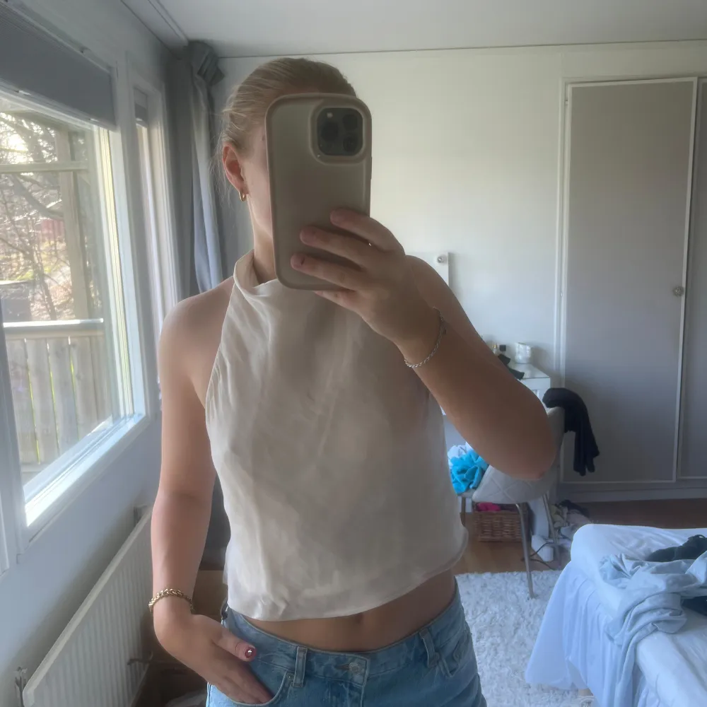 Säljer en stilren vit ärmlös topp från Zara. Toppen har en hög hals och öppen rygg, vilket ger en modern look. Topp från Hm storlek S. Inga defekter . Yläosat.