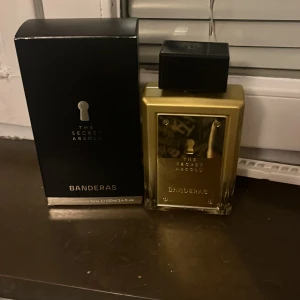 The Secret Absolut Parfym från Banderas 100 ml - Säljer en elegant parfymflaska av The Secret Absolut från Banderas. Flaskan har en lyxig guldig design med en svart kork och kommer i en stilren svart förpackning. Perfekt för den som vill ha en sofistikerad doftupplevelse. 98-100 ml kvar har bara sprayat ungefär 2-5 gånger. Köpt för ungefär 600 spänn. Priset kan diskuteras Den var bara inte min favorit 