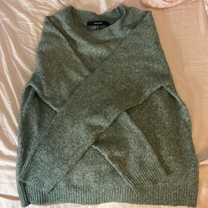Grön stickad tröja från Vero Moda - Mysig grön stickad tröja från Vero Moda i storlek L. Tröjan har en klassisk rund halsringning, långa ärmar och ribbade muddar vid ärmslut och nederkant. Perfekt för lager-på-lager och chill dagar.
