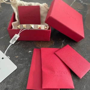 Valentino armband med guldnitar - Snyggt armband från Valentino i ljusrosa läder med guldnitar, även justerbart spänne. Skicket är bra men tydlig syn på användning därav priset, skriv för fler bilder!😊