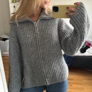 Grå stickad kofta med dragkedja - Mysig grå stickad kofta med hög krage, köpt för några månader sen och endast använd två gånger!