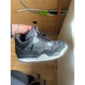 Nike Jordan 4 Retro Black Canvas - Nike Jordan 4 Retro Black Canvas är en ikonisk sneaker med svart canvas och mocka, grå detaljer och klassisk meshpanel. Snygg design med Jumpman-logga på plösen och synlig Air-sula.Skorna är använda ett fåtal gånger och därför är dem i mycket bra skick! Priset kan diskuteras!