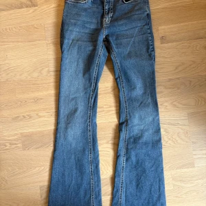 Blå bootcut jeans från Gina tricot - Snygga blå jeans från Gina tricot i klassisk bootcut-modell. Jeansen har normal passform, fem fickor och är tillverkade i slitstarkt denim. Perfekta för dig som gillar en tidlös look med lite utsvängda ben.