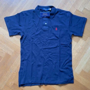Marinblå pikétröja från Ralph Lauren - Snygg marinblå pikétröja från Polo Ralph Lauren, säljer även den då den inte passade 