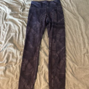 Svarta leggings med mönster - Snygga svarta leggings med diskret mönster och hög midja. Perfekta för träning eller chill, sitter tajt och följer kroppen. Materialet är stretchigt och mjukt, vilket gör dem riktigt bekväma att ha på sig hela dagen.