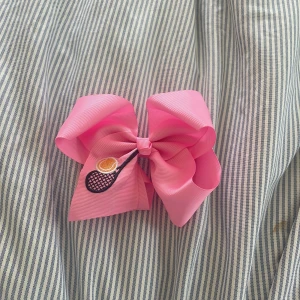 Rosa diademrosett med tennisbrodyr -  Rosa rosett  med broderad tennissymbol. Snygg detalj för dig som gillar sportig stil. Fästes med metallklämma på baksidan. Perfekt accessoar för att sticka ut på tennisbanan eller i vardagen.