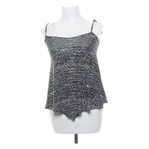 Svartvit mönstrad linnetopp Gina Tricot - Svartvit linnetopp från Gina Tricot med smala axelband och asymmetrisk nederkant. Toppen har ett grafiskt mönster, mjukt tyg och är lätt och luftig, perfekt för varma dagar. Enkel att matcha med jeans eller kjol för en cool look. Storleken är XS men passar en S också.