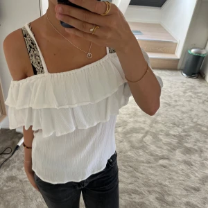 Vit volangtopp med offshoulder - Superfin vit topp med dubbla volanger och offshoulder-modell. Tunt, krinklat tyg och smala axelband ger en luftig känsla. Perfekt för varma dagar när du vill ha en romantisk och trendig look. Den är från Gekås Ullared knappt använd.