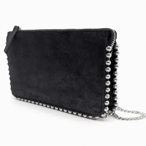 Svart kuvertväska med kedja - Stilren svart kuvertväska med coola silverfärgade kuldetaljer längs kanterna och en tunn kedjerem. Väskan har dragkedja upptill och en minimalistisk look som passar till många outfits. Den är köpt från Zara för 259kr, men säljer den för 159kr. Den har använd ett fåtal gånger och ser ut som ny.