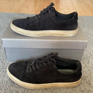 Svarta mockasneakers från Vagabond - Stilrena svarta sneakers från Vagabond i mjuk mocka med klassisk snörning och beige sula. Skorna har rund tå och en enkel, clean design som passar till det mesta. Perfekta för dig som gillar en avslappnad men snygg look.
