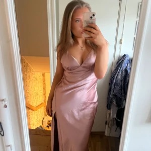 Rosa balklänning i satin med slits - Säljer en vacker balklänning i satin, den e ljusrosa/smutsrosa🌸storlek 42(på bilden har jag den i 40) klänningen är ganska stor i brösten💗
