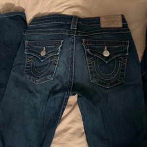 Mörkblåa jeans från true religion - True religion jeans som jag älskar men tyvärr säljer! Dessa har använts en del men funkar fortfarande skit bra, de är sönder slitna nedre delen av byxorna vid hälen. Är 162cm lång och dessa går precis till hälen på mig!