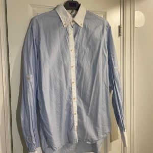 Blå och vit skjorta från Stenströms - Snygg blå och vit randig skjorta från Stenströms med klassisk krage och knappar framtill. Skjortan har långa ärmar och är perfekt för en stilren look. Tillverkad i ett bekvämt material som passar bra till olika tillfällen.