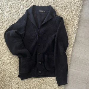 Mörkblå overshirt från Dressmann - Snygg mörkblå overshirt från Dressmann i storlek S. Den har en klassisk design med knappar framtill och två praktiska fickor. Inte alls använd många gånger. Priset kan vid snabb affär diskuteras.