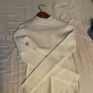 Vit ribbad polotröja - Säljer en stilren vit ribbad polotröja med långa ärmar. Perfekt för kyligare dagar och ger en elegant look. Passar bra till både jeans och kjol. Hör av dig vid intresse!