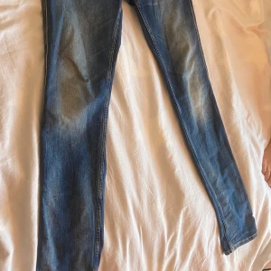 Blå jeans från Replay Anbass - Snygga blå jeans från Replay Anbass med en klassisk femficksdesign och ljusa tvättade detaljer. De har en knappgylf och märkesdetaljer på fickan. Perfekta för en avslappnad stil. Waist 31 and length 34!