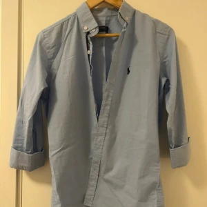 Ljusblå skjorta från Ralph Lauren - Otroligt fin skjorta från Ralph lauren storlek S, inga defekter och passar någon som är 170cm, jag är 180 och är nog för stor för den! Nypris ca 1700kr | mitt pris 399kr!!!! Pris går att diskuteras vid smidig affär