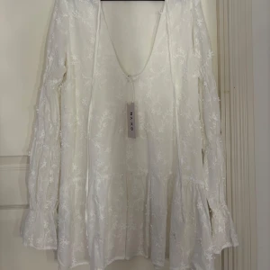 Vit blommig klänning  - Säljer denna super söta klänningen från Na-kd! Den är aldrig använd, därför är prislappen kvar. Ny pris 799kr. Perfekt för alla tillfällen!✨🩷