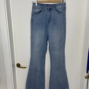 Blå bootcut jeans från Shein - Snygga blå bootcut jeans från Shein i storlek S. Dessa jeans har en klassisk femficksdesign och en knappgylf. Perfekta för en trendig look med sin utsvängda stil.