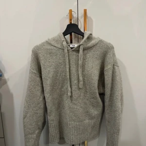 Grå stickad hoodie från Zara - Mysig grå stickad hoodie från Zara med ribbade muddar och dragsko i huvan. Perfekt för kyliga dagar när du vill vara både bekväm och stilren.❤️‍🔥