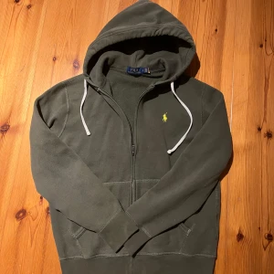 Grön Ralph Lauren full zip - Tja, säljer den här riktigt snygga Ralph lauren hoodien i mycket bra skick. Den är perfekt nu till våren och sköna sommarkvällar. Riktigt bra pris eftersom nyköp ligger runt 2000kr. Det är bara att höra av sig vid frågor och funderingar🤩👍
