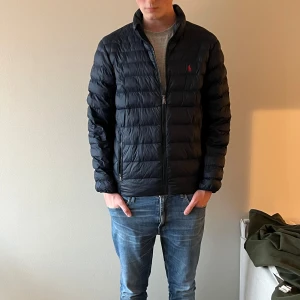 Ralph Lauren Tunn dunjacka  - Mörkblå Ralph Lauren tunn dun jacka med röd häst. Modell Colden packable jacket. Herr M, Nyprjs 4295:-