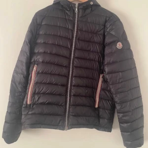Moncler jacka  - En Moncler saison jacka. Riktigt snygg. Jackan är från 2009 då den ej har någon qr kod scan. Jackan har sina defekter då den har varit med i gameat i 16 år nu( det är ej några stora defekter bara lite smått) den stora dragkjedjan har gått sönder men har fixat det med en annan dragkjedja. Allt stämmer bra med jacka ! Hör av er vid minsta frågor eller funderingar. Priset kan sänkas vid snabb afär! Storlek 3 motsvarar L.
